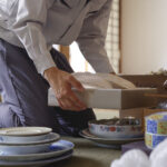 食器を抱える男性